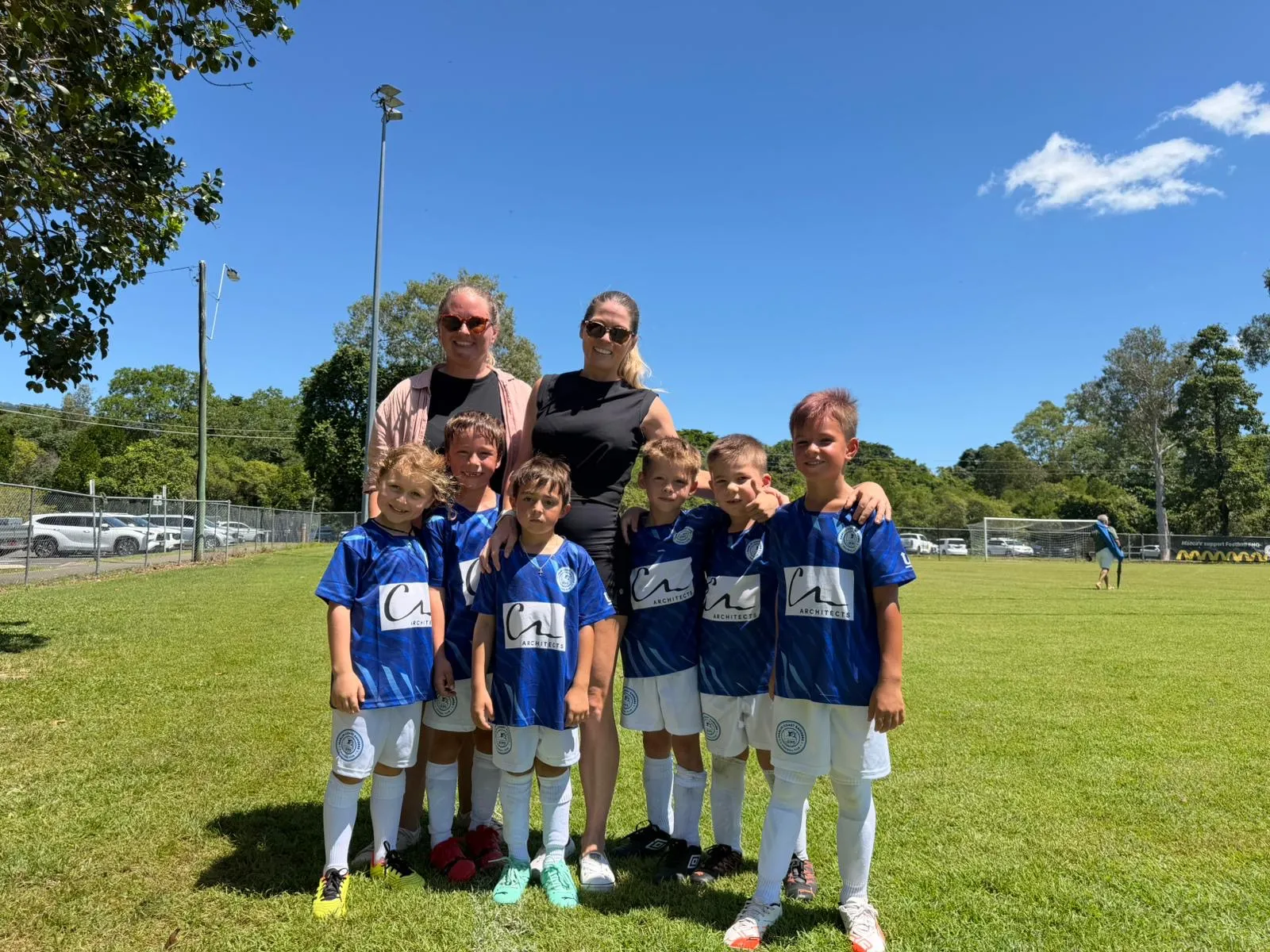 Young Marlin Coast Rangers players in club kit with two team managers at Pennell Field, Cairns